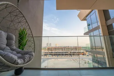 a chair on a building with a view of a pool at EasyGo - Chic Studio Escape in Dubai Sports City in Dubai