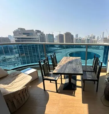 a patio with a table and chairs on a balcony at Helena - spacious studio with canal view and big Balcony in Dubai