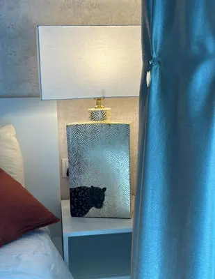 a blue nightstand with a black cat box next to a bed at Helena - spacious studio with canal view and big Balcony in Dubai