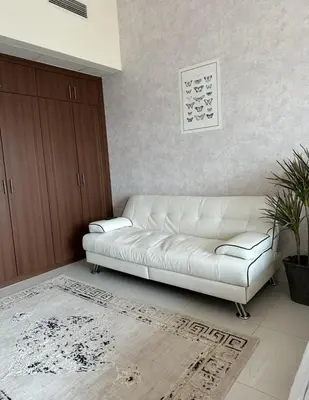 a white couch sitting in a living room at Helena - spacious studio with canal view and big Balcony in Dubai
