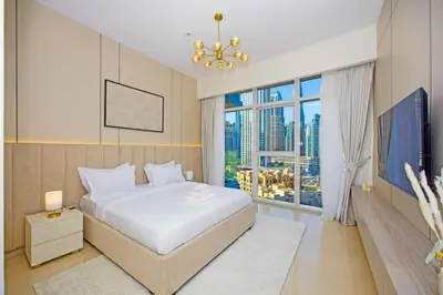 a bedroom with a white bed and a large window at Premium 2BR at Imperial Avenue overlooking Burj Khalifa in Dubai