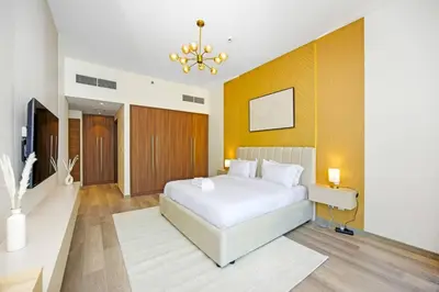 a bedroom with a white bed and a chandelier at Premium 2BR at Imperial Avenue overlooking Burj Khalifa in Dubai