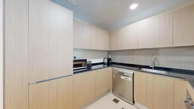 a small kitchen with wooden cabinets and a sink at Locations l Spectacular 4 Bed Villa l Garden l Wadi Al Safa in Dubai