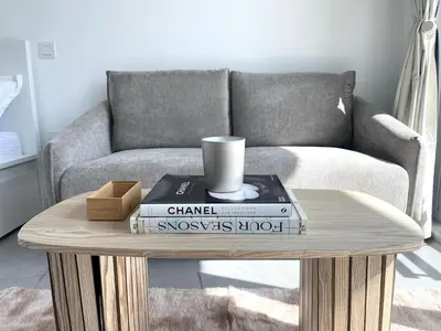 a coffee table with books and a couch at Stunning New Studio - Near Dubai Hills Mall in Dubai