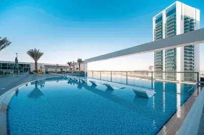 a large swimming pool in front of a building at Stunning New Studio - Near Dubai Hills Mall in Dubai