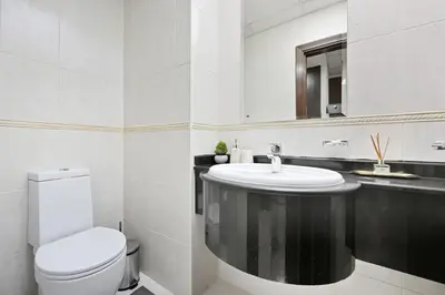 a bathroom with a toilet and a sink and a mirror at Luxury 1BD in Elite Residence, Dubai Marina in Dubai