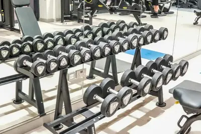 a row of dumbbell racks in a gym at Stunning - Cozy Studio - Azizi Riviera in Dubai