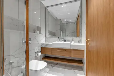 a bathroom with a sink and a toilet and a mirror at Charming 2BR Getaway at Azizi Riviera, MBR City in Dubai