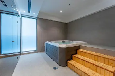 a bathroom with a large tub and a window at 1BDR near Circle Mall with Sauna, Jaccuzzi and Gym in Dubai