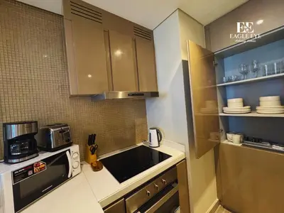 a small kitchen with a sink and a microwave at EagleEye Paramount Tower D 1BR Sleeps 4 in Dubai