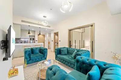 a living room with two blue couches at ALiving Elegant 1BR I Golf Gate, DAMAC Hills in Dubai