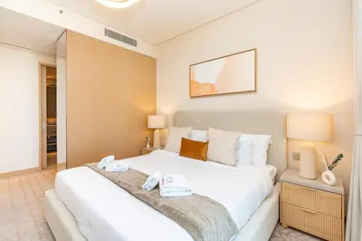 a bedroom with a large white bed with towels on it at PVH - Burj Khalifa View 2BR - Vida Dubai Mall in Dubai