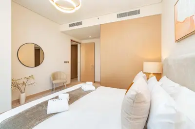 a bedroom with a white bed and a mirror at PVH - Burj Khalifa View 2BR - Vida Dubai Mall in Dubai