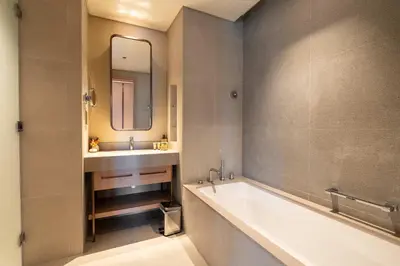 a bathroom with a tub and a sink and a mirror at PVH - Burj Khalifa View 2BR - Vida Dubai Mall in Dubai