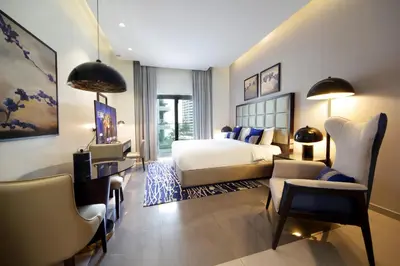 a bedroom with a bed and a table and chairs at Silk Valley - Luxury DAMAC Studio near Dubai Mall & Burj Khalifa in Dubai