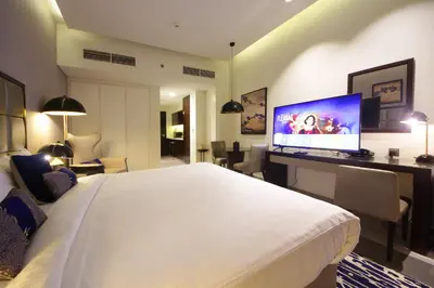 a hotel room with a large bed and a television at Silk Valley - Luxury DAMAC Studio near Dubai Mall & Burj Khalifa in Dubai