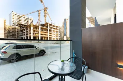 a table and chairs on a balcony with a car at HAVN - Modern Studio in Dusk, Al Barsha in Dubai