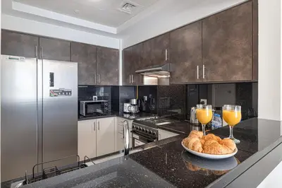 a kitchen with a counter with two glasses of orange juice at Deluxe Nine Tower Suites By Hostiva - Downtown in Dubai