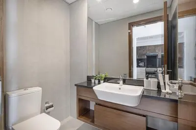 a bathroom with a sink and a toilet and a mirror at Deluxe Nine Tower Suites By Hostiva - Downtown in Dubai