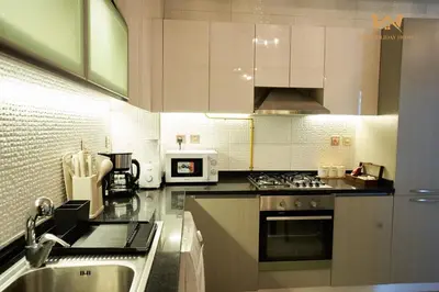 a kitchen with a sink and a stove top oven at Wake Up to the Burj Khalifa Stunning view 1BR Stay in Dubai