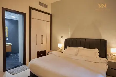 a bedroom with a large white bed and a bathroom at Wake Up to the Burj Khalifa Stunning view 1BR Stay in Dubai