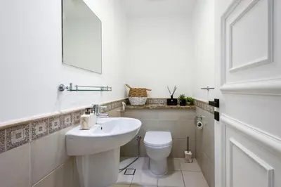 a white bathroom with a sink and a toilet at Spacious 1BR with Terrace l Near Palm Jumeirah Mall in Dubai