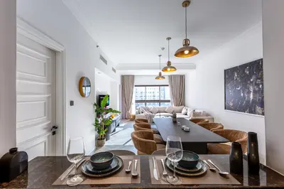a living room with a table and a couch at Spacious 1BR with Terrace l Near Palm Jumeirah Mall in Dubai