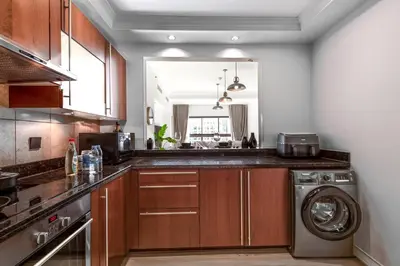 a kitchen with a washing machine and a sink at Spacious 1BR with Terrace l Near Palm Jumeirah Mall in Dubai
