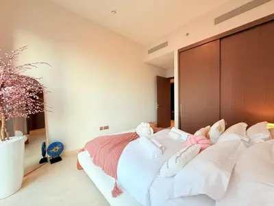 a bedroom with a large bed with pink and white pillows at UNIQUE - BURJ KHALIFA & FOUNTAIN ViEW-4 BR in Dubai