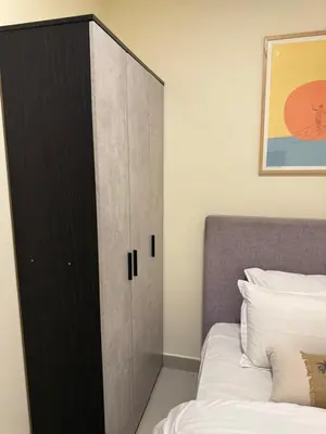 a bedroom with a black cabinet next to a bed at Joyful Journeys Marina Arcade Private Room for 2 - Shared Kitchen in Dubai