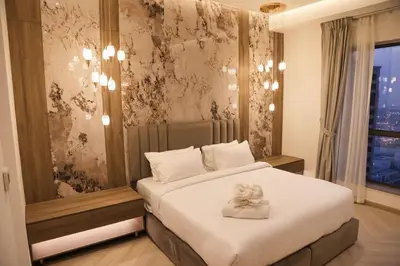 a bedroom with a large white bed with a window at The Royale Vista Burj Khalifa View Residence in Dubai