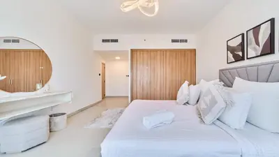 a white bedroom with a large bed and a mirror at fam Living High Floor Stay in Sulafa Tower in Dubai