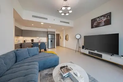 a living room with a blue couch and a flat screen tv at Stunning Full Burj Khalifa and Fountain View Apartment in Dubai