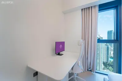 a white desk with a computer on it next to a window at Burj Khalifa - Fountain View - Astonishing Home in Dubai