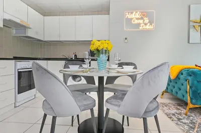 a kitchen with a table with chairs and a vase of flowers at Vibrant 1 Bedroom Marina View - Stylish and Bright Stay in Dubai