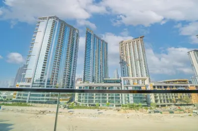 a group of tall buildings on a beach at EasyGo - Elegant 1-Bedroom Apartment with Balcony in Dubai