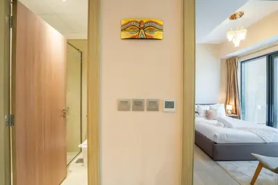 a bedroom with a bed and a painting on the wall at EasyGo - Elegant 1-Bedroom Apartment with Balcony in Dubai