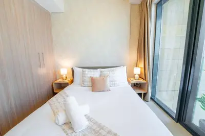 a bedroom with a bed and a large window at EasyGo - Elegant 1-Bedroom Apartment with Balcony in Dubai