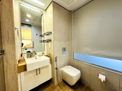 a bathroom with a white toilet and a sink at Palm Jumeirah Lifestyle - Elegant Waterfront Studio in Dubai