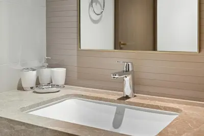 a bathroom with a sink and a mirror at Luxury 2BR Emaar Beachfront with Private Beach & Infinity Pool, Palm Jumeirah & Atlantis Views in Dubai