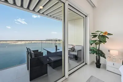 a dining room with a view of the ocean at Luxury 2BR Emaar Beachfront with Private Beach & Infinity Pool, Palm Jumeirah & Atlantis Views in Dubai