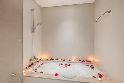 a bath tub filled with red roses in a bathroom at Luxury 2BR Emaar Beachfront with Private Beach & Infinity Pool, Palm Jumeirah & Atlantis Views in Dubai