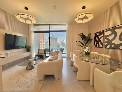 a living room with a couch and a table and chairs at Artistic 2Bedroom with Skyline Khalifa View in Dubai