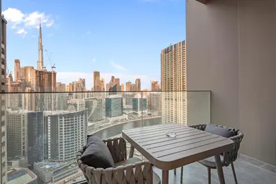 a table and chairs on a balcony with a view of a city at Artistic 2Bedroom with Skyline Khalifa View in Dubai