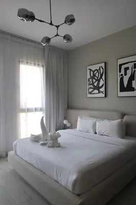 a bedroom with a large white bed with a bird on it at 1BR Madinat Jumeirah Living in Dubai
