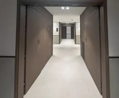 an empty corridor of an office building with brown doors at GRANDE SIGNATURE with a direct Burj Khalifa view and Private Fountain Show at 62nd floor with DXB AIRPORT VIP Shuttle option for 6 guests in Dubai
