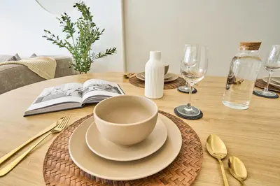 a table with a coffee cup and a book on it at Luxury 1BR Downtown Modern Urban Stay in Dubai