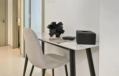 a white table with a chair and a box on it at Zada 1BR High Floor - Stunning View 1min Downtown and 2min to Metro in Dubai