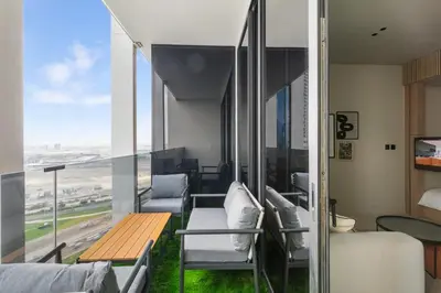 a room with a balcony with chairs and a table at Executive Studio in Business Bay with Working Area, Pool, Gym in Dubai