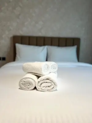 a pile of towels sitting on top of a bed at Elegant Studio Stay in Binghatti Tulip Dubai in Dubai